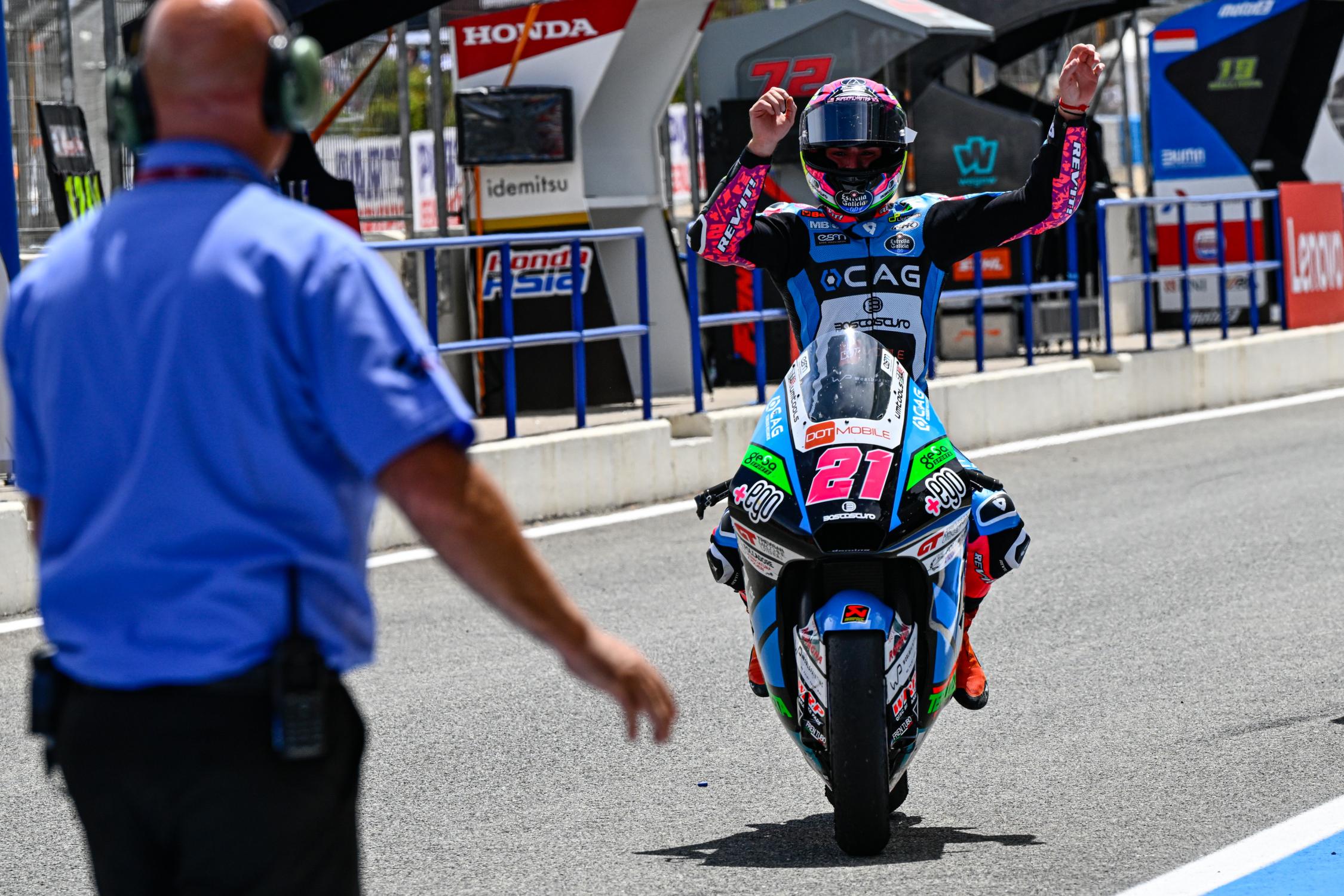 Une personne qui pose son casque de moto sur ça moto . il pleut et